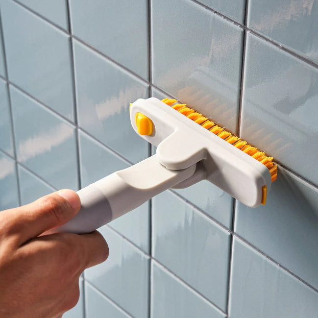 Person using a tile grout cleaning tool on a tiled wall
