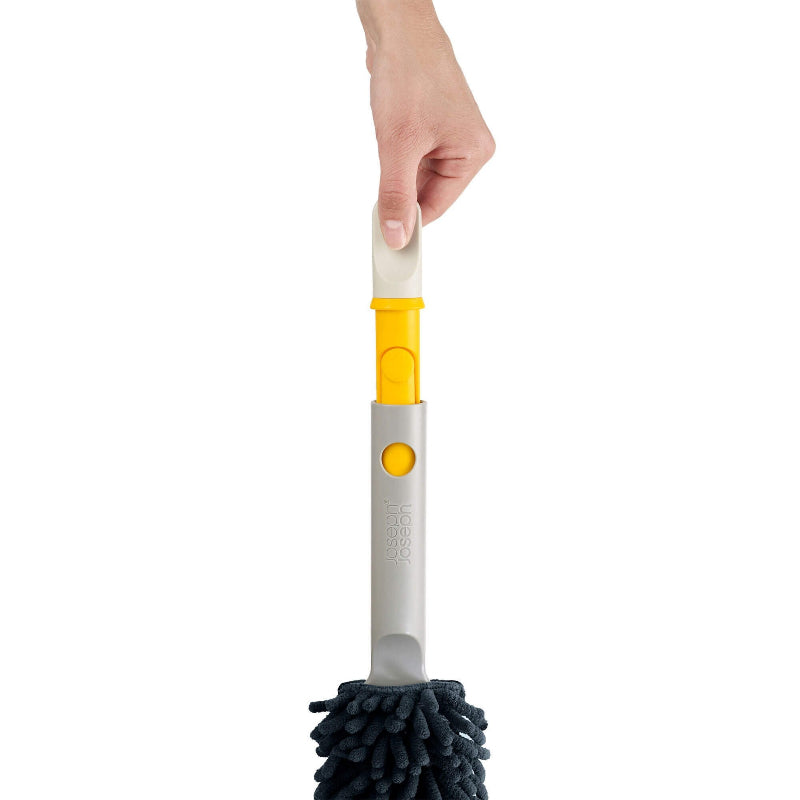 Cleaning brush with a hand holding it on a white background