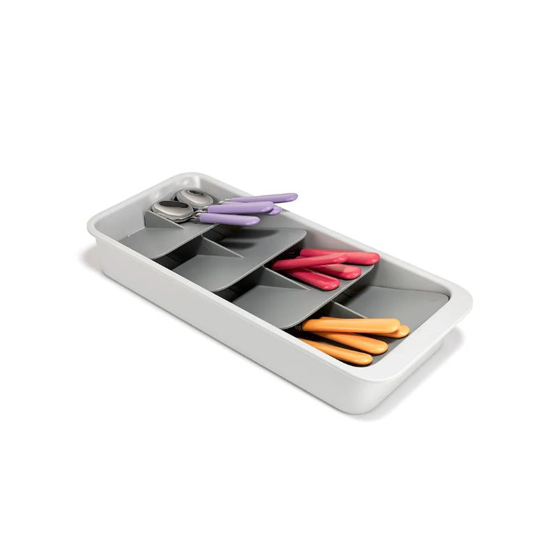 White tray with compartments containing colourful cutlery on a white background