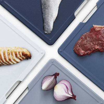 Four cutting boards with different food items on a white background