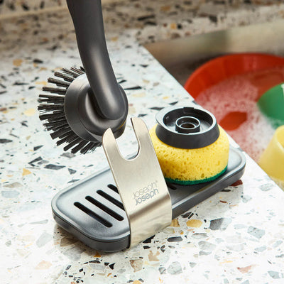 Kitchen scrubber set with holder on a speckled countertop