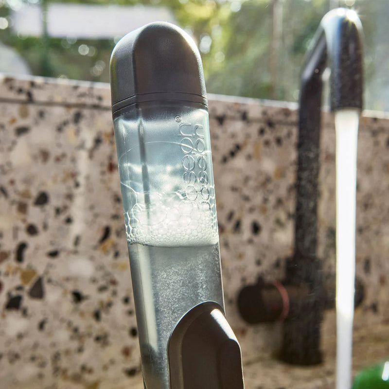 Close-up of a water bottle with a pump on a textured surface