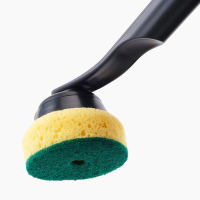 Cleaning brush with yellow and green sponge head on a white background