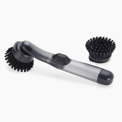 Two washing up brushes with black bristles on a white background