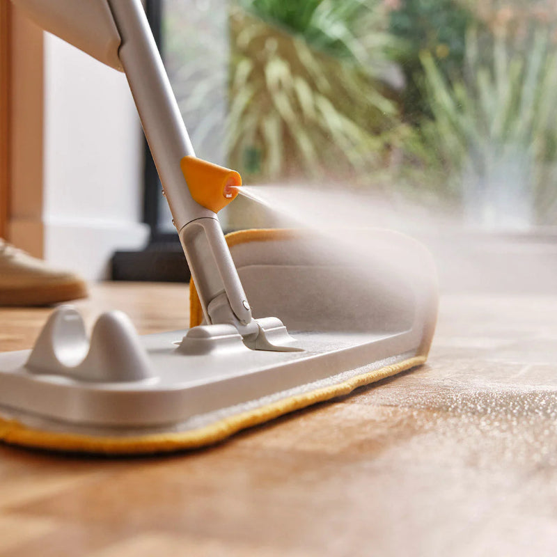 Person using a mop to clean a wooden floor.
