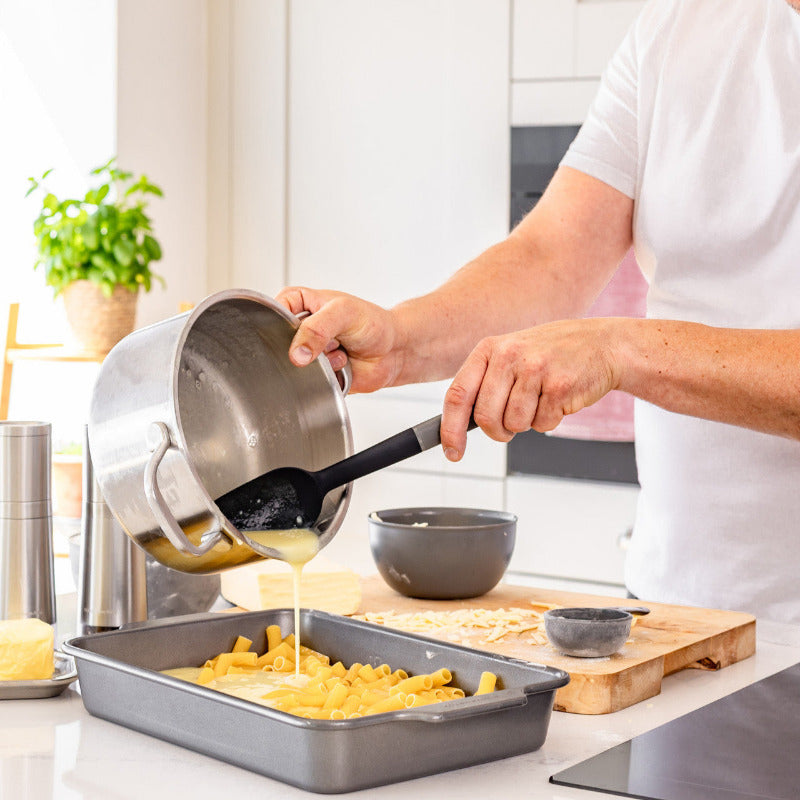 Person cooking pasta in a kitchen