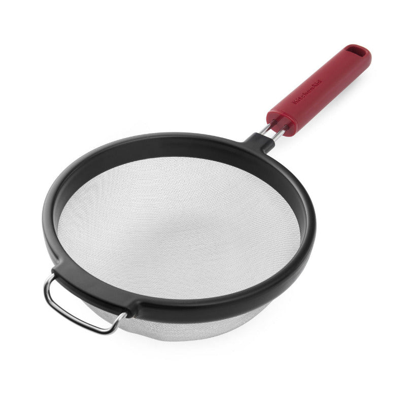 Mesh strainer with red handle on a white background