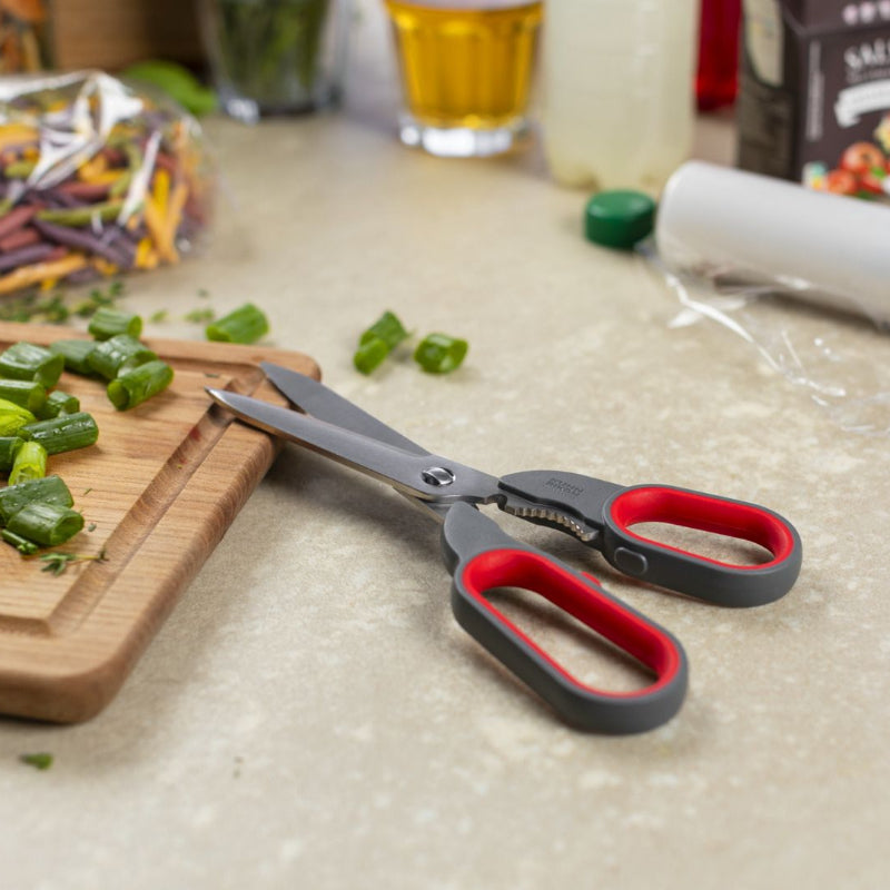 Shears on a kitchen counter with vegetables and other items