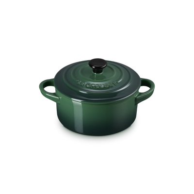 Green enameled cast iron round Dutch oven on a white background