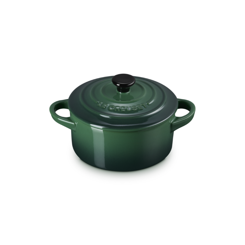 Green enameled cast iron round Dutch oven on a white background