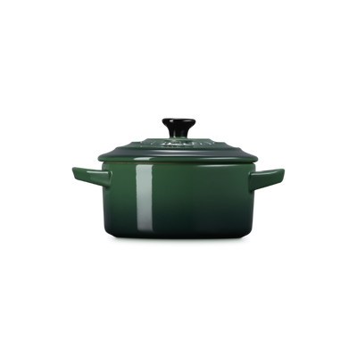 Green enameled cast iron cocotte on a white background