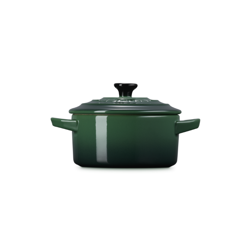 Green enameled cast iron cocotte on a white background