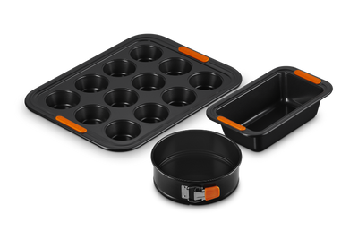Set of black baking pans with orange accents on a white background