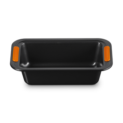 Black loaf pan with orange handles on a white background