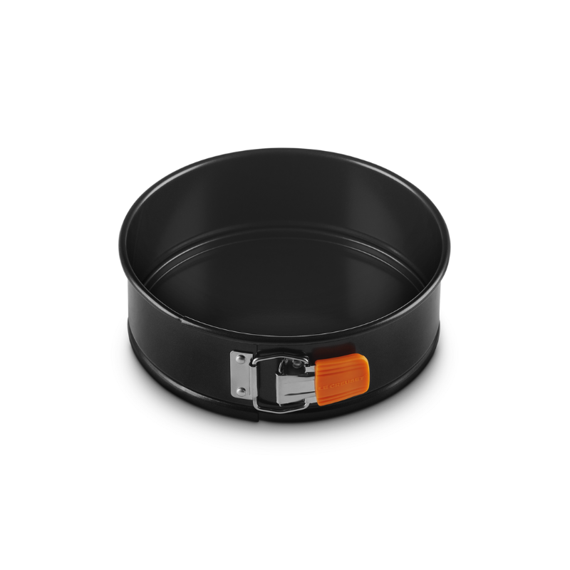 Black springform pan with a handle on a white background