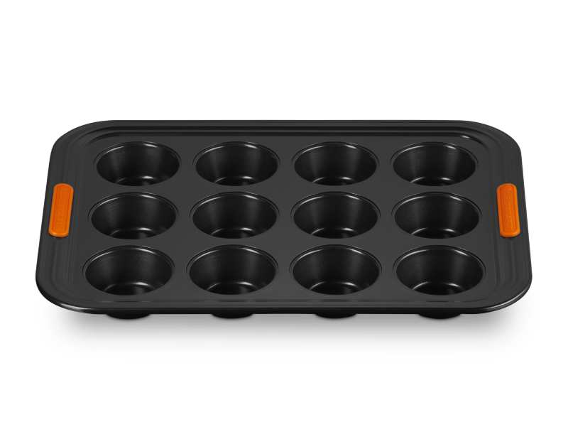 Black muffin tin with orange handles on a white background
