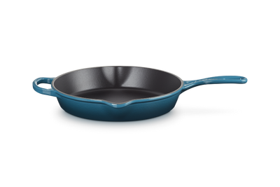 Blue enameled cast iron skillet on a white background