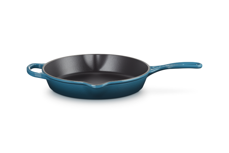 Blue enameled cast iron skillet on a white background