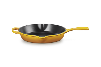 Yellow frying pan with a black interior on a white background