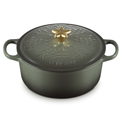 Black cast iron cookware pot with decorative lid on a white background