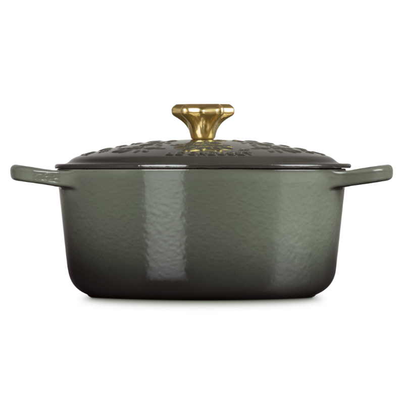 Green cast iron cookware with a gold handle on a white background