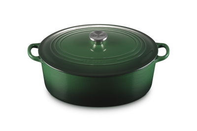Green enameled cast iron Dutch oven with lid on a white background