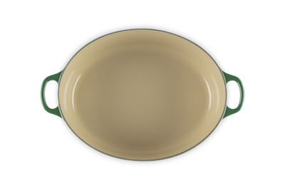 Green oval baking dish with handles on a white background