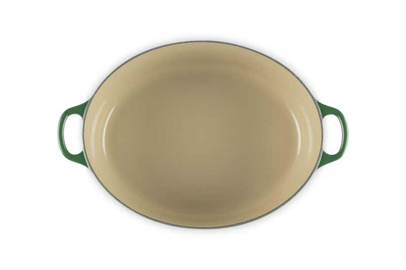 Green oval baking dish with handles on a white background