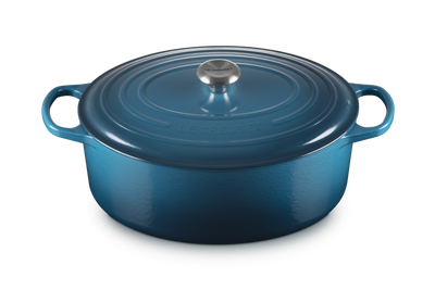 Blue enameled cast iron Dutch oven with a lid on a white background