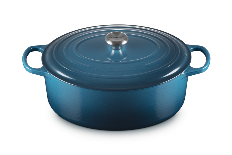 Blue enameled cast iron Dutch oven with a lid on a white background