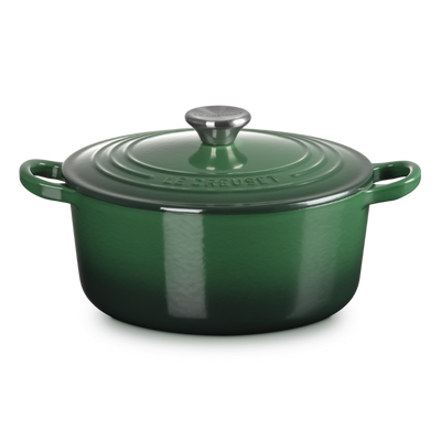 Green enameled cast iron Dutch oven on a white background