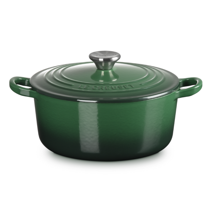 Green enameled cast iron Dutch oven on a white background