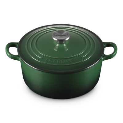 Green cast iron cookware pot on a white background
