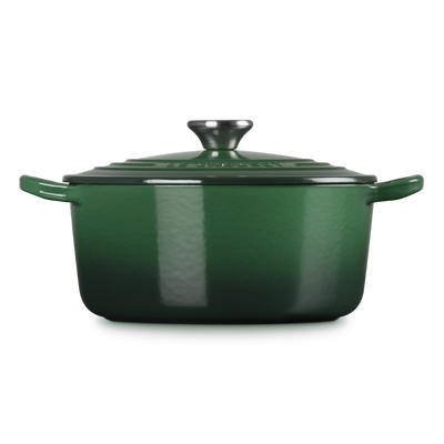 Green enameled cast iron Dutch oven on a white background