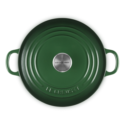 Green round cast iron cookware with handles on a white background