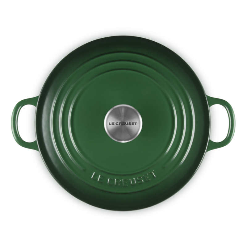 Green round cast iron cookware with handles on a white background
