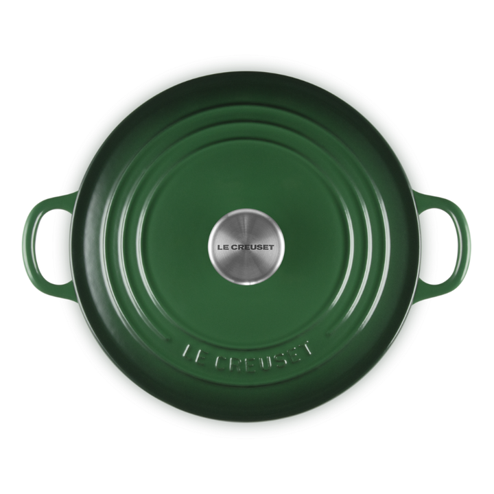Green round cast iron cookware with handles on a white background