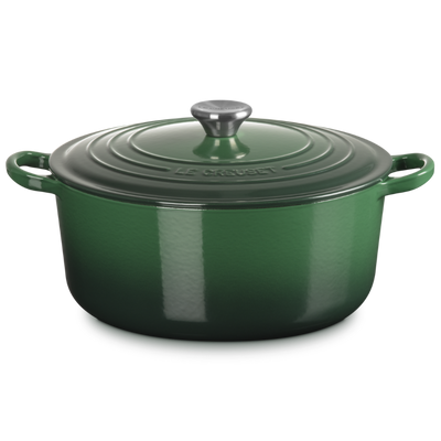Green enameled cast iron Dutch oven with lid on a white background