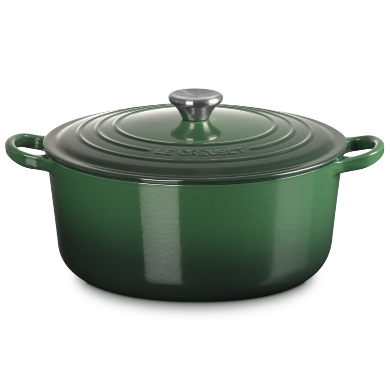 Green enameled cast iron Dutch oven with lid on a white background