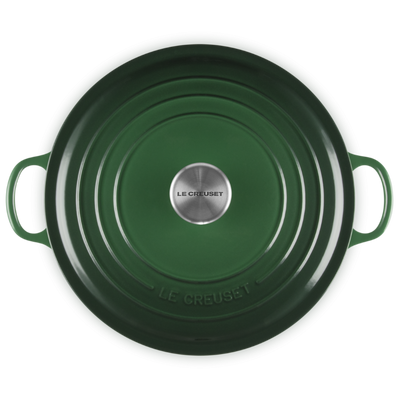 Green cast iron cookware with 'Le Creuset' branding on a white background