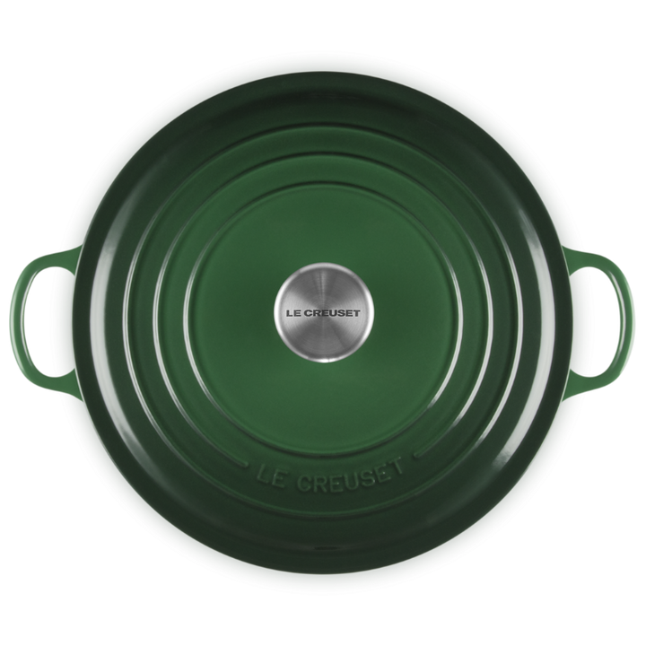 Green cast iron cookware with 'Le Creuset' branding on a white background