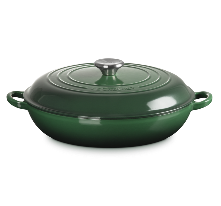 Green cast iron cookware with lid on a white background
