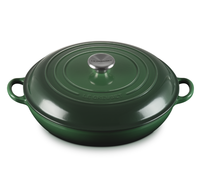 Green cast iron cookware with a lid on a white background