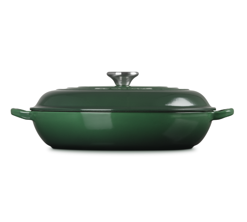 Green enameled cast iron casserole dish with lid on a white background