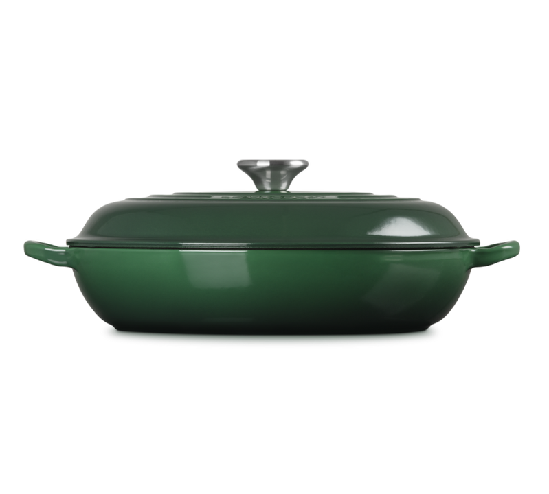 Green enameled cast iron casserole dish with lid on a white background