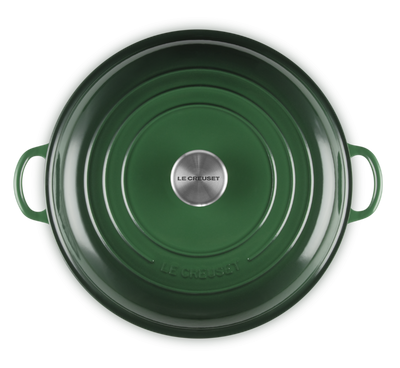 Green cast iron pot with lid on a white background