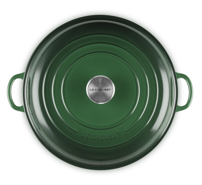 Green cast iron pot with lid on a white background