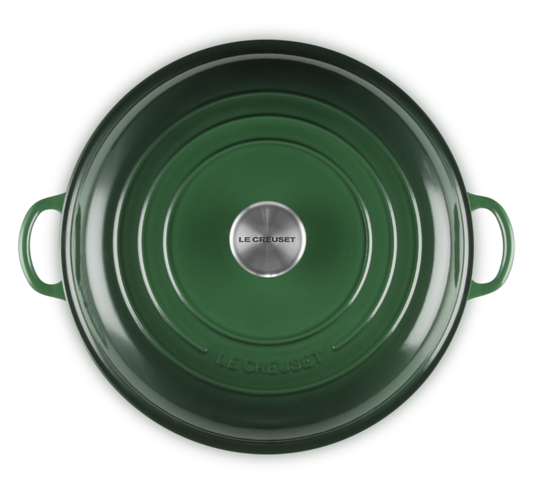 Green cast iron pot with lid on a white background