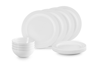Set of white ceramic plates and bowls on a black background