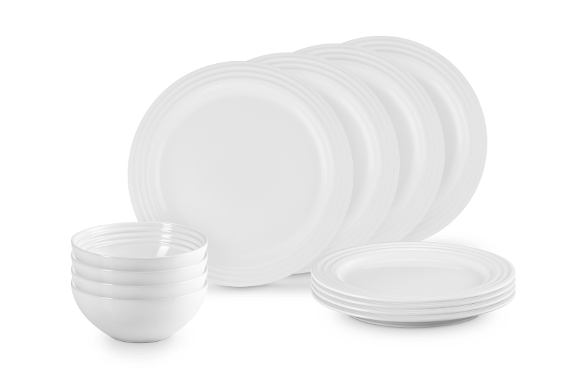 Set of white ceramic plates and bowls on a black background